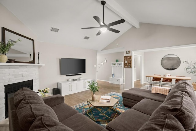 living room with a fireplace, high vaulted ceiling, a ceiling fan, visible vents, and light wood-style flooring