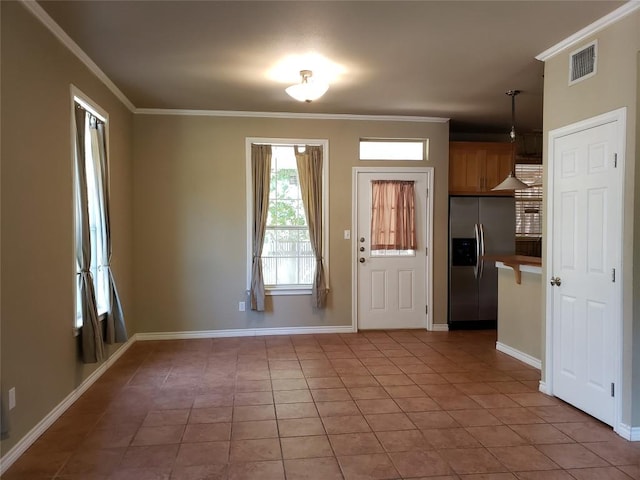 foyer entrance with light tile patterned floors, visible vents, baseboards, and crown molding