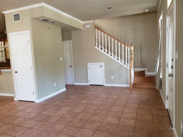 tiled foyer entrance featuring ornamental molding, visible vents, baseboards, and stairway