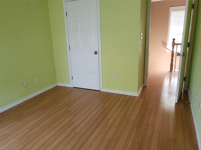 unfurnished bedroom featuring wood finished floors and baseboards