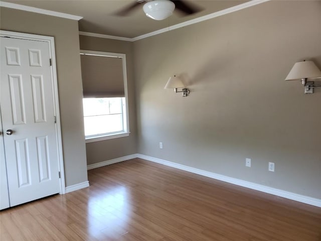 unfurnished bedroom featuring crown molding, baseboards, a ceiling fan, and wood finished floors