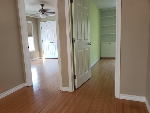 corridor with light wood-style floors and baseboards