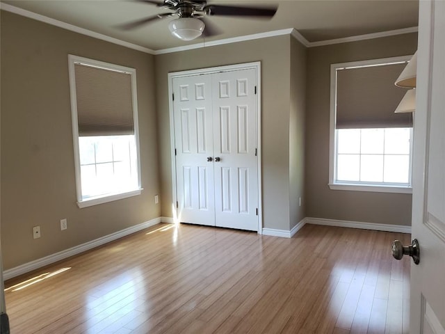 unfurnished bedroom with ornamental molding, multiple windows, and wood finished floors