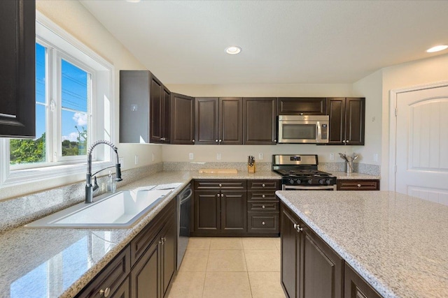 11208 Mickelson Dr, Austin, TX 78747 - kitchen with appliances with stainless steel finishes, dark brown cabinets, light tile patterned floors, recessed lighting, and light stone counters