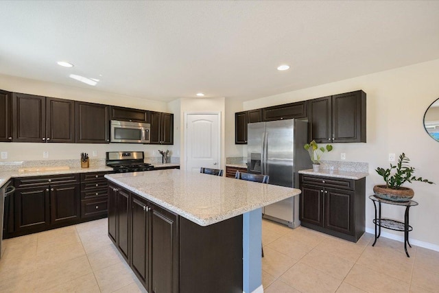 11208 Mickelson Dr, Austin, TX 78747 - kitchen with stainless steel appliances, a kitchen island, light tile patterned floors, light stone countertops, and recessed lighting