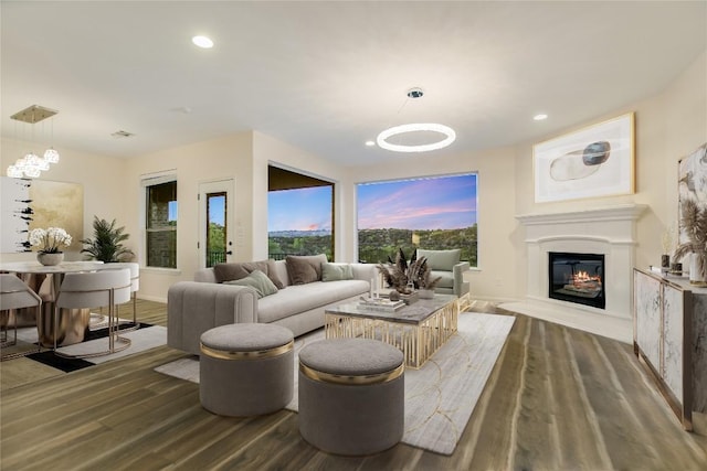 12325 Labrador Bay Ct, Austin, TX 78732 - living room featuring wood finished floors, a glass covered fireplace, recessed lighting, baseboards, and a chandelier