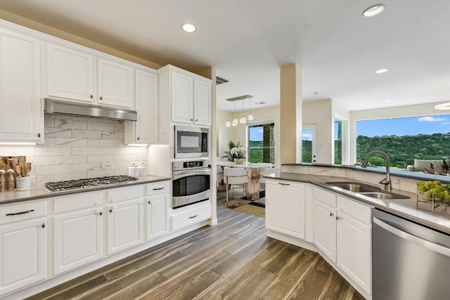 12325 Labrador Bay Ct, Austin, TX 78732 - kitchen with appliances with stainless steel finishes, a sink, backsplash, white cabinets, and dark wood finished floors