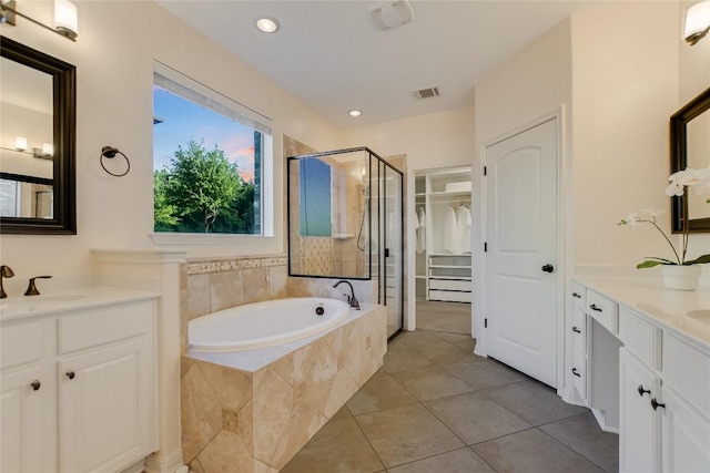 12325 Labrador Bay Ct, Austin, TX 78732 - bathroom featuring a stall shower, two vanities, tile patterned flooring, a garden tub, and recessed lighting
