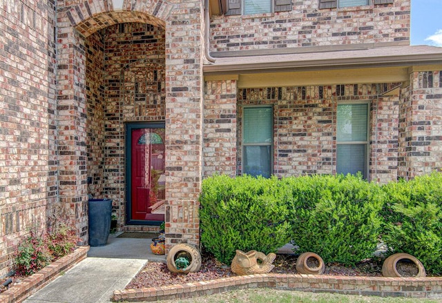 doorway to property featuring brick siding