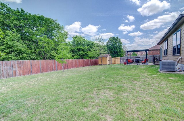 view of yard featuring a fenced backyard, central air condition unit, an outdoor structure, a patio, and a storage unit