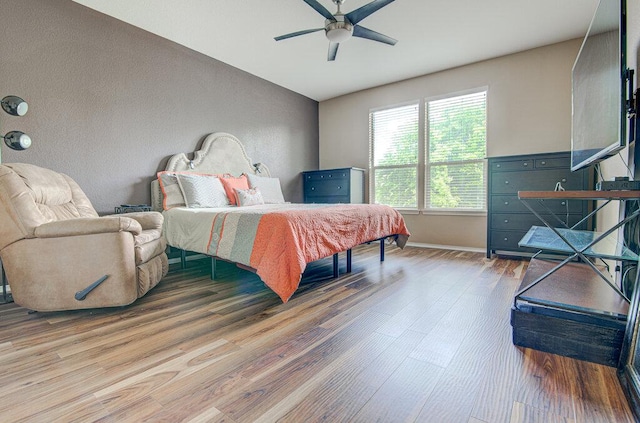 bedroom featuring wood finished floors, baseboards, and ceiling fan
