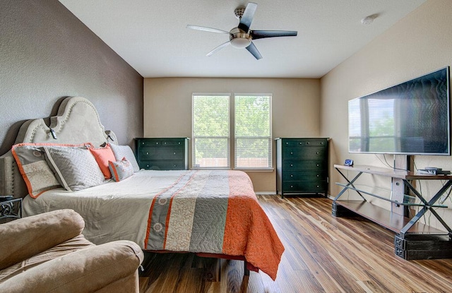 bedroom with baseboards, a ceiling fan, and wood finished floors