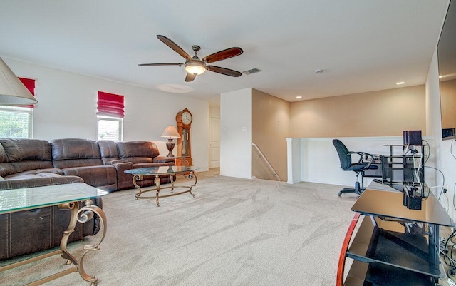 living area featuring a ceiling fan, visible vents, and carpet