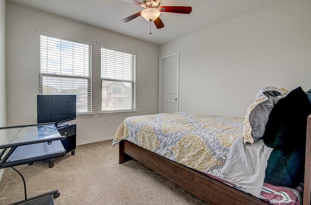 carpeted bedroom featuring baseboards and a ceiling fan
