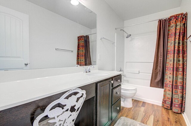 bathroom with shower / bath combo, toilet, vanity, and wood finished floors