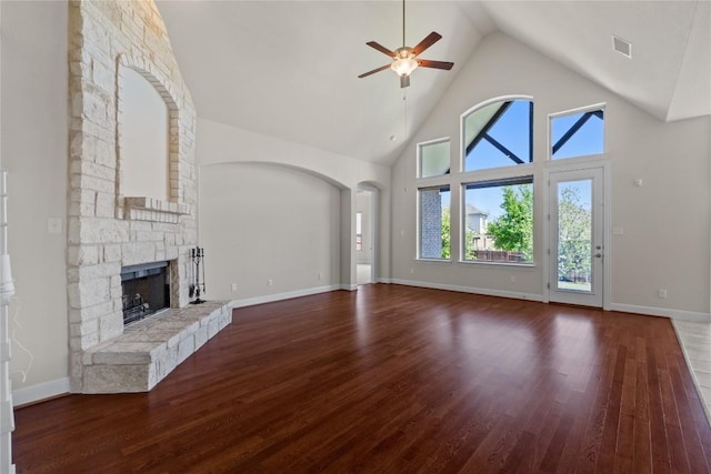 118 Bluehaw Dr, Georgetown, TX 78628 - unfurnished living room with a ceiling fan, high vaulted ceiling, a fireplace, wood finished floors, and arched walkways
