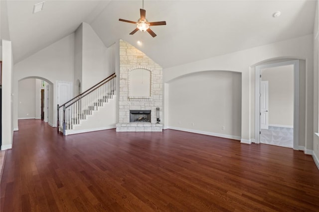 118 Bluehaw Dr, Georgetown, TX 78628 - unfurnished living room featuring a ceiling fan, a fireplace, wood finished floors, high vaulted ceiling, and arched walkways