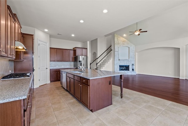 118 Bluehaw Dr, Georgetown, TX 78628 - kitchen featuring a ceiling fan, stainless steel appliances, under cabinet range hood, open floor plan, and decorative backsplash