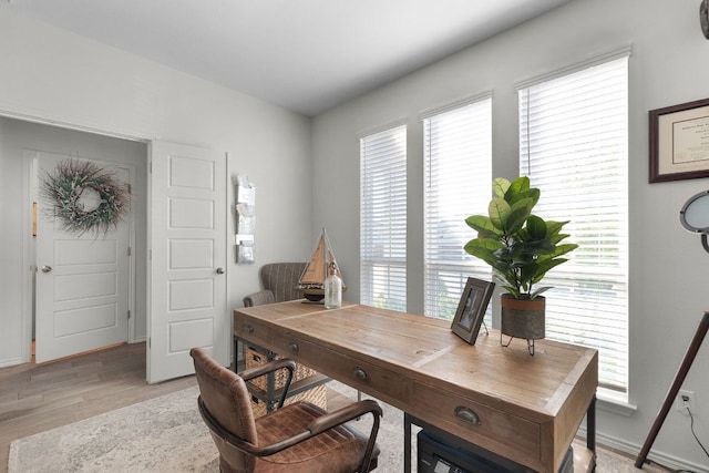 home office with baseboards and light wood finished floors