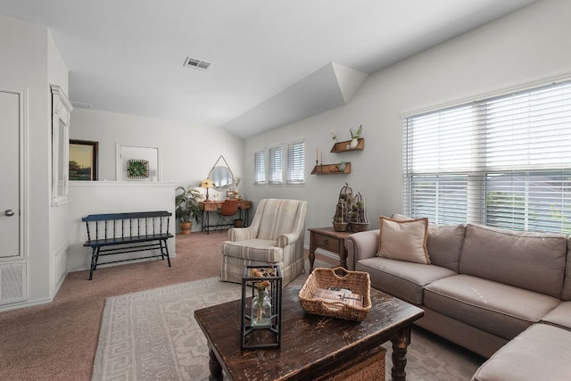 carpeted living area featuring visible vents, baseboards, and lofted ceiling