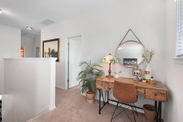 home office with visible vents, baseboards, and light colored carpet