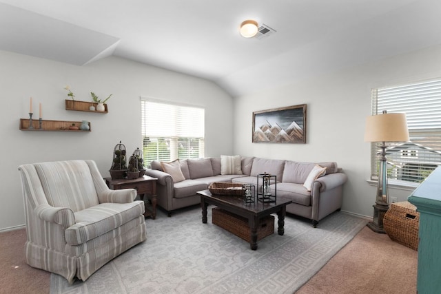 living area with light carpet, visible vents, baseboards, and vaulted ceiling