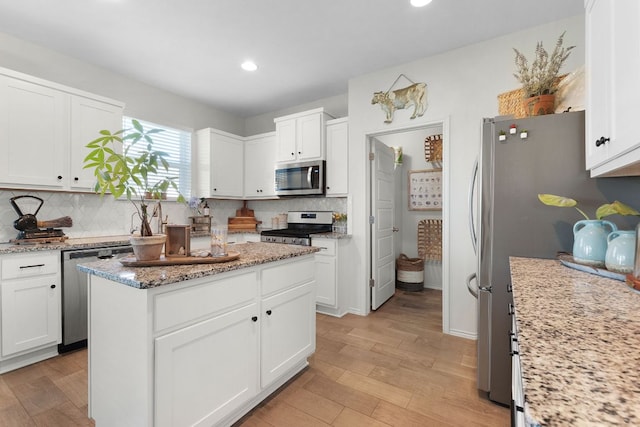 kitchen with tasteful backsplash, white cabinetry, and stainless steel appliances