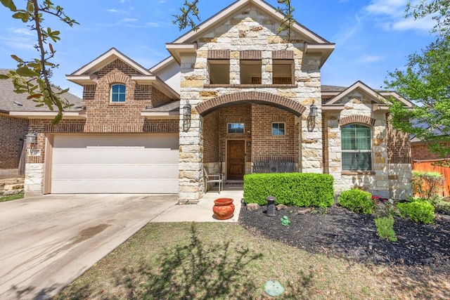view of front facade featuring stone siding, driveway, an attached garage, fence, and brick siding