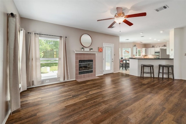 2204 Rick Whinery Dr, Austin, TX 78728 - living room featuring ceiling fan, dark wood finished floors, a tile fireplace, and baseboards