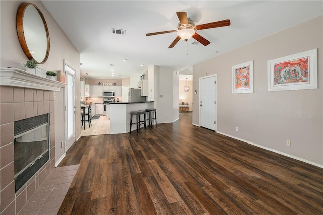 2204 Rick Whinery Dr, Austin, TX 78728 - living room featuring a ceiling fan, wood finished floors, and a fireplace