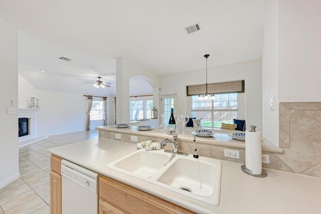 2709 Quiet Moon Trl, Cedar Park, TX 78613 - kitchen with white dishwasher, a sink, ceiling fan, open floor plan, and a glass covered fireplace