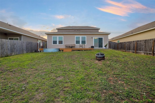 14209 Jeannette Rankin Rd, Manor, TX 78653 - back of property at dusk featuring an outdoor fire pit and a deck