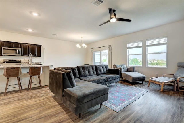 14209 Jeannette Rankin Rd, Manor, TX 78653 - living room featuring light wood-style flooring, a chandelier, and ceiling fan