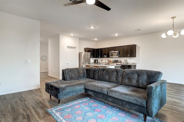 14209 Jeannette Rankin Rd, Manor, TX 78653 - living room featuring a ceiling fan, wood finished floors, baseboards, a chandelier, and recessed lighting