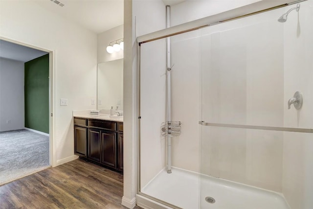 14209 Jeannette Rankin Rd, Manor, TX 78653 - bathroom with a shower stall, wood finished floors, double vanity, and baseboards