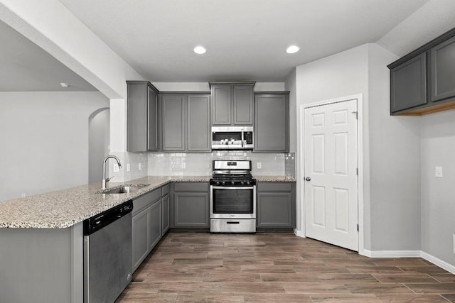 100 Grouger Cv, Leander, TX 78641 - kitchen featuring appliances with stainless steel finishes, a sink, gray cabinets, a peninsula, and recessed lighting