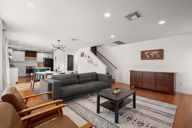 12305 Kelton Dr, Austin, TX 78754 - living room featuring recessed lighting, stairway, a chandelier, and light wood-style floors
