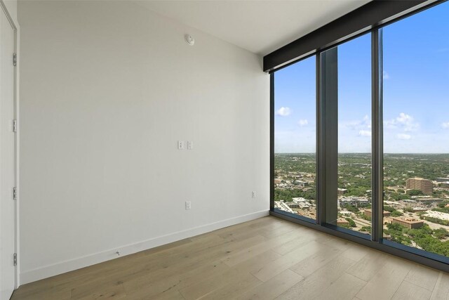 44 E Ave Unit 4302, Austin, TX 78701 - empty room with expansive windows, wood finished floors, and healthy amount of natural light