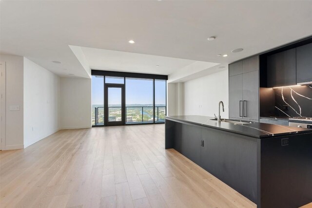 44 E Ave Unit 4302, Austin, TX 78701 - kitchen with expansive windows, modern cabinets, open floor plan, light wood-type flooring, and an island with sink