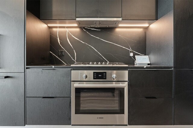 44 E Ave Unit 4302, Austin, TX 78701 - kitchen with stainless steel appliances, range hood, modern cabinets, and decorative backsplash