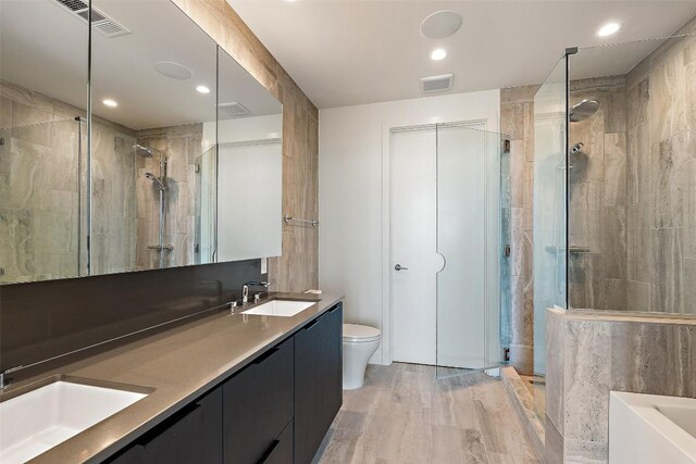 44 E Ave Unit 4302, Austin, TX 78701 - bathroom with a shower stall, double vanity, a bathtub, wood finished floors, and recessed lighting