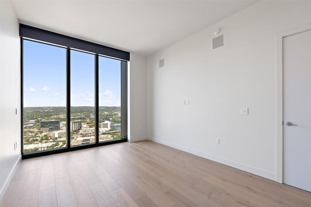 44 E Ave Unit 4302, Austin, TX 78701 - spare room featuring plenty of natural light, wood finished floors, expansive windows, and a smoke detector