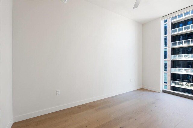 44 E Ave Unit 2307, Austin, TX 78701 - unfurnished room featuring wood finished floors, a ceiling fan, and expansive windows