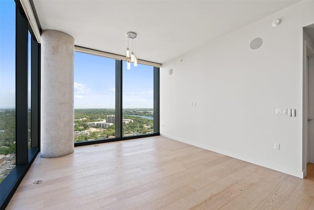 44 E Ave Unit 2307, Austin, TX 78701 - spare room featuring expansive windows, wood finished floors, and baseboards