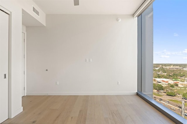 44 E Ave Unit 2307, Austin, TX 78701 - empty room featuring light wood-style flooring, baseboards, and expansive windows