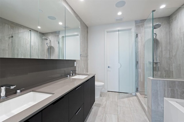 44 E Ave Unit 2307, Austin, TX 78701 - bathroom featuring a stall shower, double vanity, a garden tub, toilet, and recessed lighting