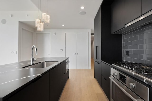 44 E Ave Unit 2307, Austin, TX 78701 - kitchen featuring dark cabinetry, modern cabinets, a sink, light wood-type flooring, and recessed lighting