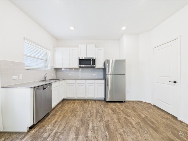 3113 Windy Vane Dr, Pflugerville, TX 78660 - kitchen featuring stainless steel appliances, a sink, tasteful backsplash, white cabinetry, and light wood finished floors