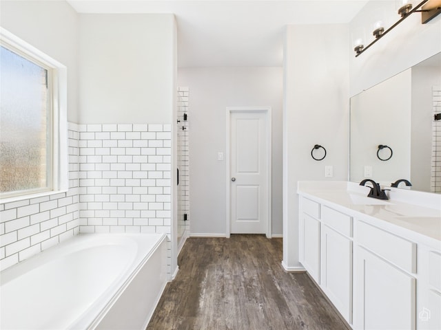 3113 Windy Vane Dr, Pflugerville, TX 78660 - full bathroom with a bath, double vanity, wood finished floors, a stall shower, and baseboards