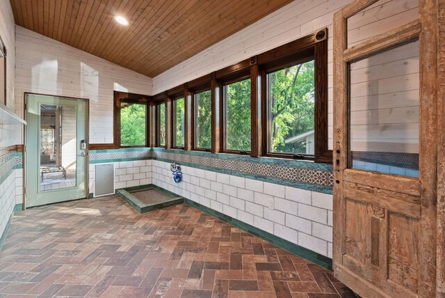 5607 Jim Hogg Ave, Austin, TX 78756 - unfurnished sunroom with wood ceiling, lofted ceiling, brick floors, wood walls, and recessed lighting